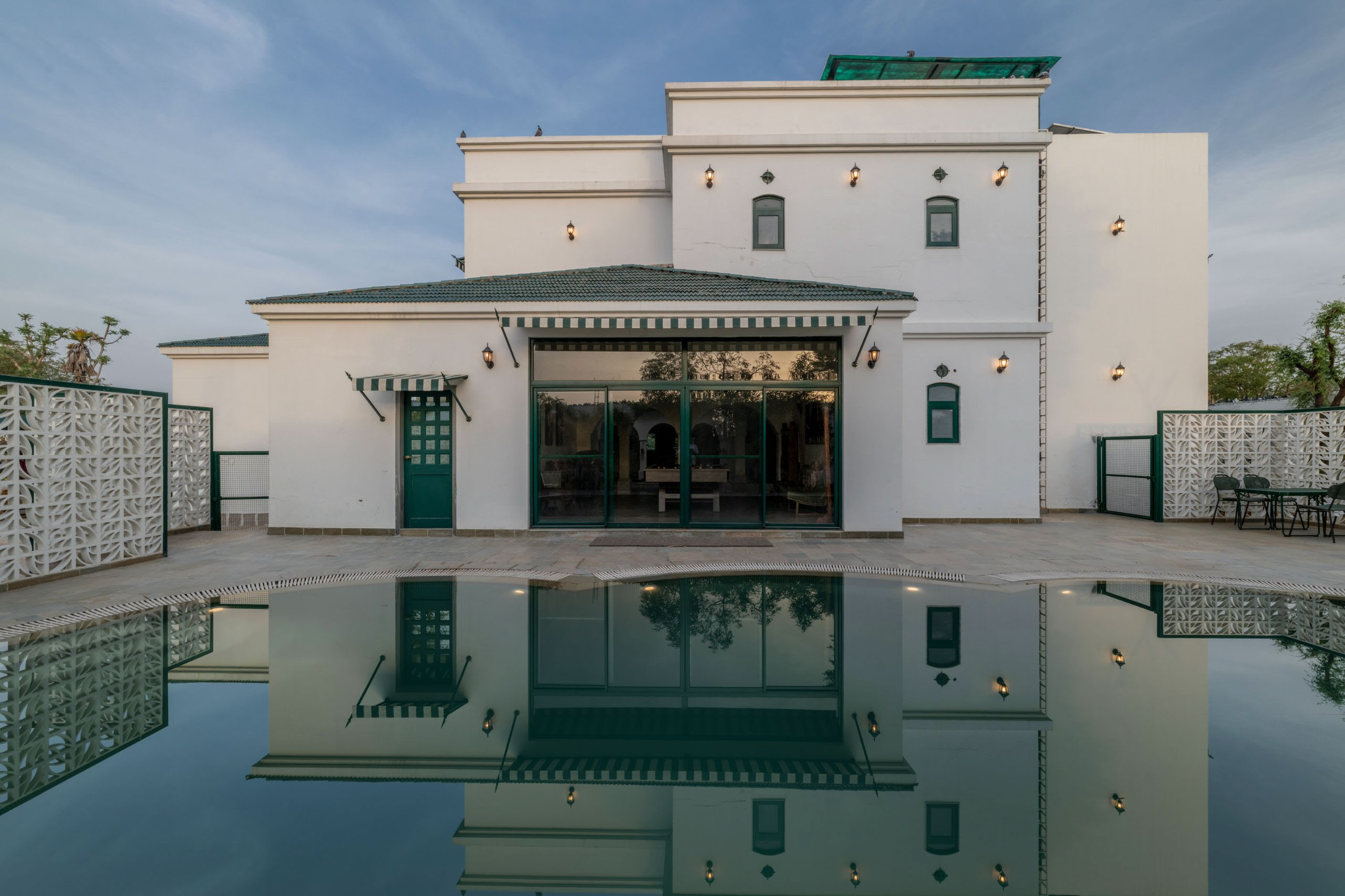 Large white house with a reflecting pool in front of it
