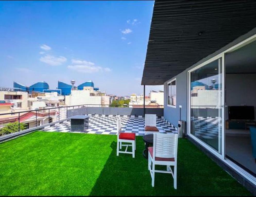 Rooftop patio with table, chairs, and couch overlooking a beautiful city view